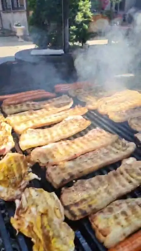 Snimak roštilja koji se dimi u bašti čarde